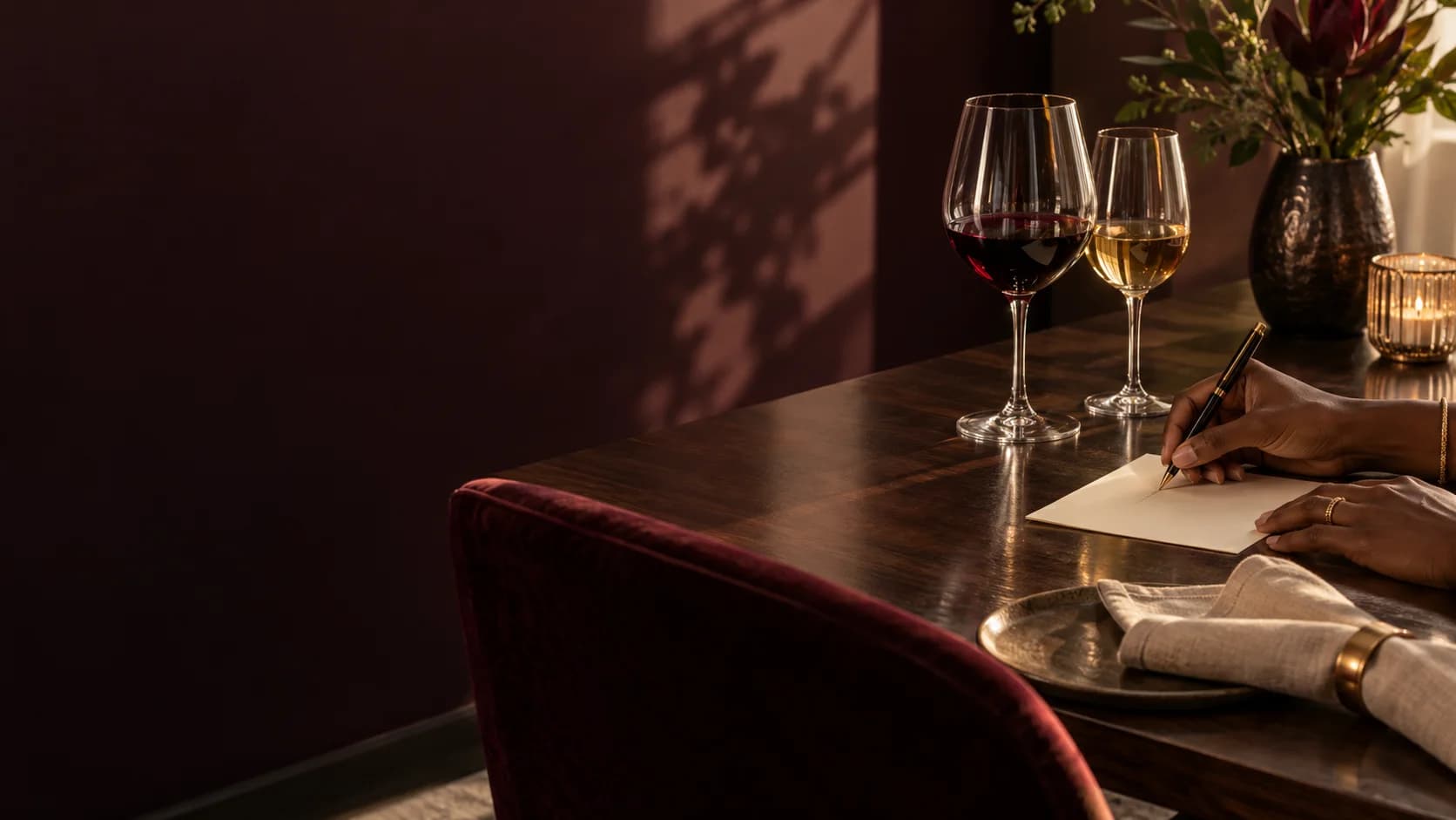 A guest writing a note beside wine glasses